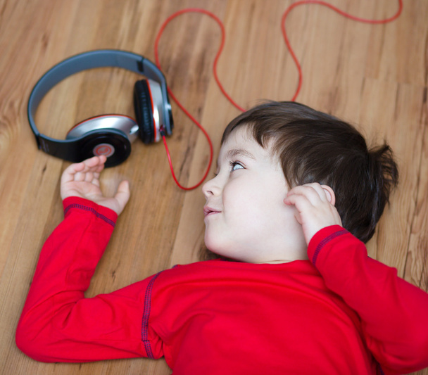 χαριτωμένο αγόρι, απολαμβάνοντας τη μουσική χρησιμοποιώντας ακουστικά - Φωτογραφία, εικόνα