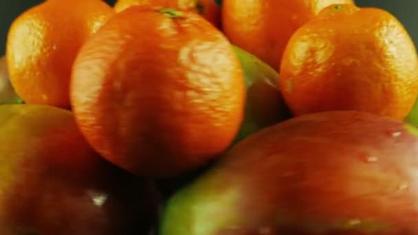 Macro-opname van roterende mango's en mandarijnen - zwarte achtergrond - Video