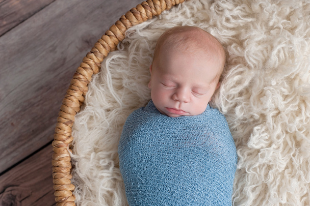 Neugeborener Junge schläft in einem Korb - Foto, Bild