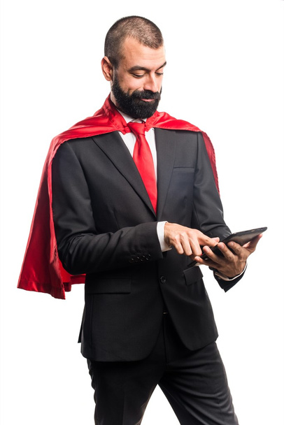 Super hero businessman holding a tablet - Foto, Imagen