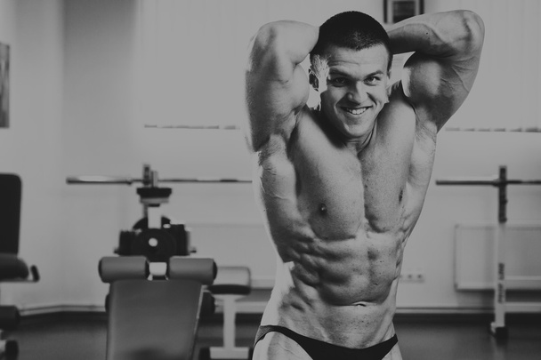 Knappe, atletische, zelfverzekerd man in de sportschool. Bodybuilding pose - Foto, afbeelding