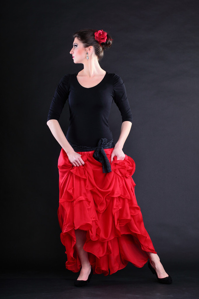 Attractive spanish young woman dancing flamenco over black backg - Foto, immagini