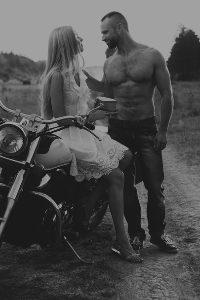 preto e branco foto motociclista casal em uma motocicleta no campo
. - Foto, Imagem
