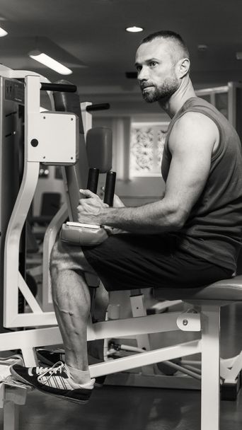 Hombre haciendo ejercicios de piernas, ejercicios en el simulador. Deportes, estilo de vida saludable
. - Foto, imagen