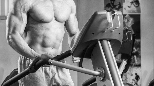 Strong muscular man doing exercises in the gym. - Photo, Image