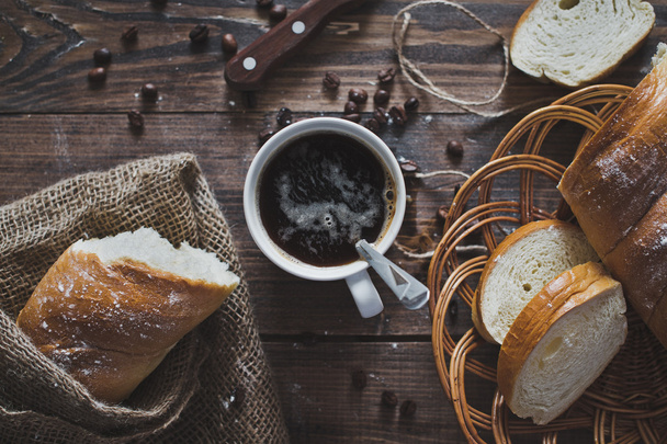 On the table is a mug of coffee and sliced the loaf 5103. - Photo, image