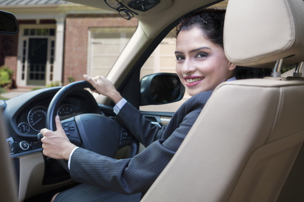 Cheerful indian woman driving new car - Foto, imagen