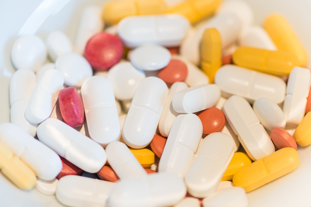 verschillende gekleurde geneeskunde pillen op witte achtergrond - Foto, afbeelding