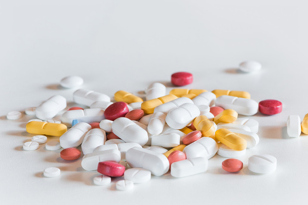 mehrere unterschiedlich farbige und große Medikamententabletten auf weiß - Foto, Bild