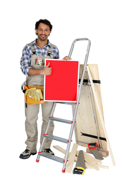 Carpenter giving the thumbs up to a board left blank for your message - Photo, Image