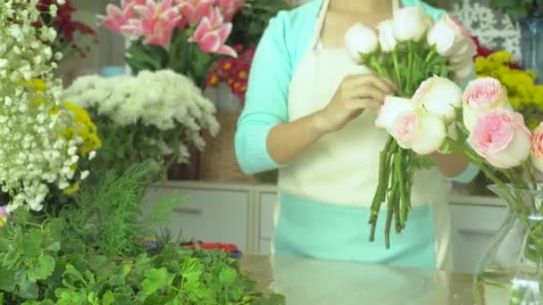 Flower shop, florist arranging pink rose bouquet - Footage, Video