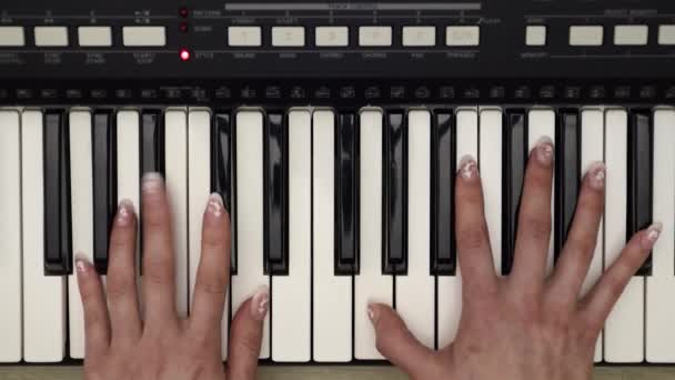 Mujer manos jugando en sintetizador, vista superior de cerca
 - Metraje, vídeo