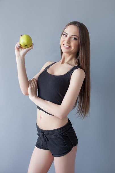 Cheerful young woman is eating healthy food - 写真・画像