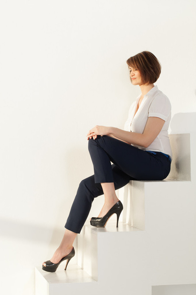 Relaxed businesswoman sitting on stairs with eyes closed - Fotoğraf, Görsel
