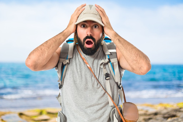 Backpacker doing surprise gesture over white background - Photo, Image