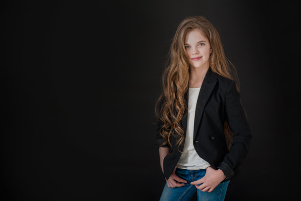 The girl the teenager with long hair on a black background - Fotografie, Obrázek