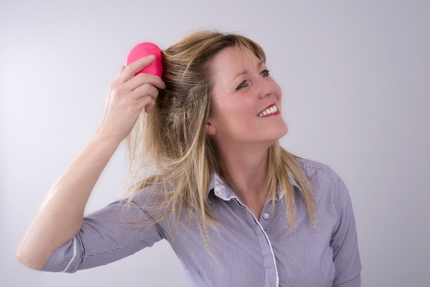 Sarışın kadın saçları fırçalama - Fotoğraf, Görsel