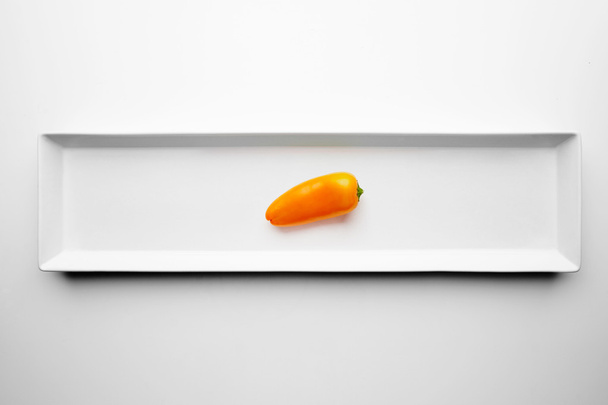 Small yellow pepper isolated in center white - Foto, Imagem