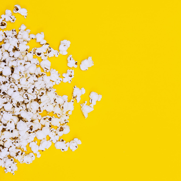 Popcorn on yellow background. Minimalism fashion detail. - Фото, изображение