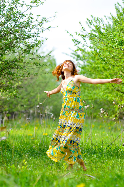 美しい少女を歩く春緑のリンゴ果樹園 - 写真・画像