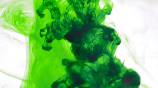 green ink slowly spread out in clear water - Materiał filmowy, wideo