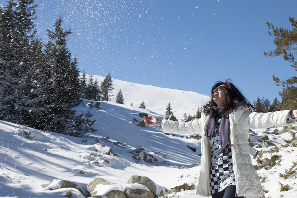 Жінка кидає сніг в повітрі в зимові канікули
 - Фото, зображення