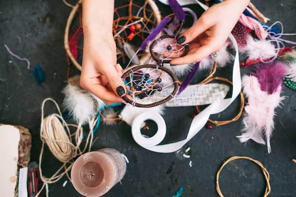 woman makes Dreamcatcher of sewing accessories. - Zdjęcie, obraz