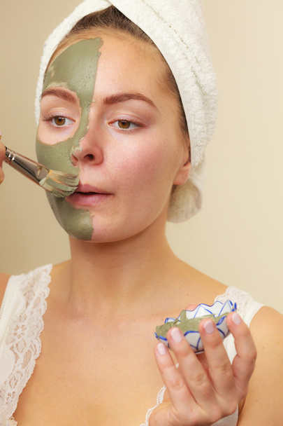 Woman applying with brush clay mud mask to her face  - Fotografie, Obrázek