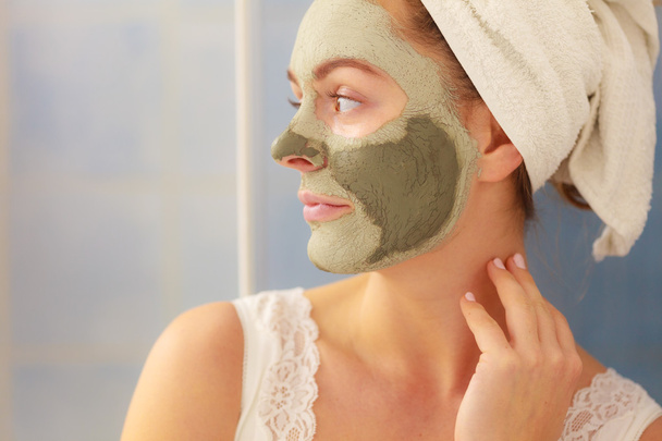 Woman face with green clay mud mask  - 写真・画像