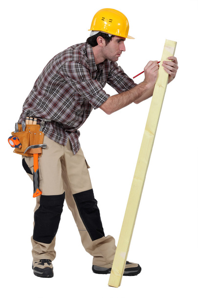 Man marking a measurement on a wooden plank - Fotografie, Obrázek