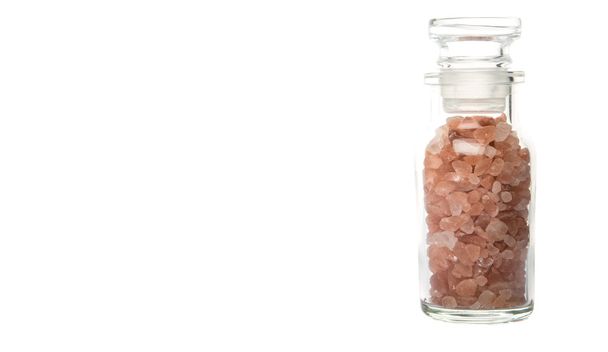 Himalayan rock salt in glass vial over white background - Photo, Image