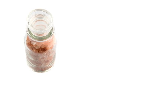 白い背景の上のガラス瓶のヒマラヤ岩塩 - 写真・画像