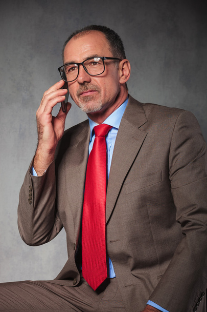 Erfolgreicher Geschäftsmann mit Brille telefoniert mit seinem Smartphone - Foto, Bild
