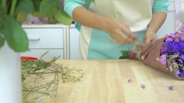 Blumenladen, Floristen arrangieren Statices Bouquet, Bänder binden, um eine Verbeugung zu machen - Filmmaterial, Video