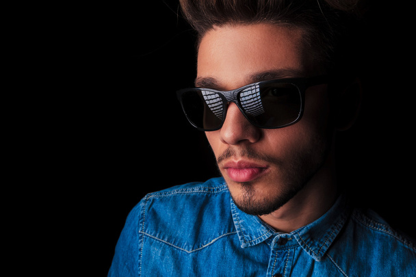 portrait of man in denim wearing sunglasses in dark studio - 写真・画像