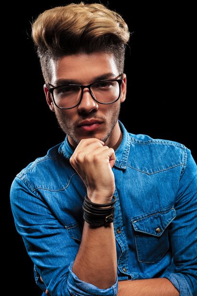 Интересный модный человек в джинсах и очках, позируя thi
 - Фото, изображение