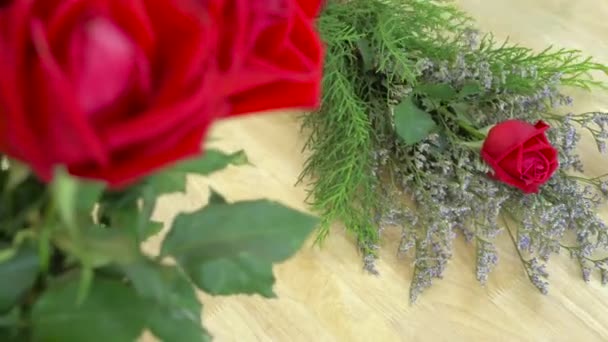 Blumenladen, Floristen arrangieren Blumenstrauß, arrangieren Zellophan und frischen roten Rosenstrauß - Filmmaterial, Video