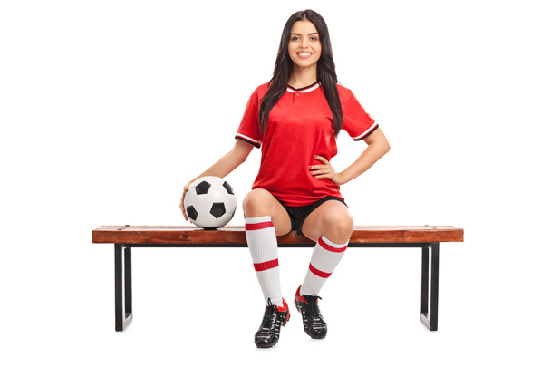 Female soccer player sitting on a bench - Фото, зображення