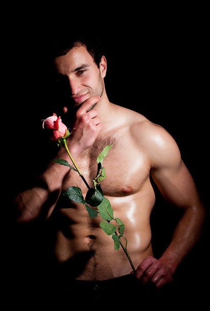 Valentines man in een mode pose met roos - Foto, afbeelding
