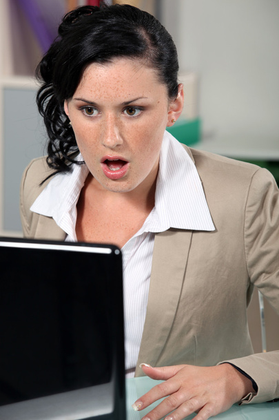 Shocked woman reading an e-mail - Foto, afbeelding