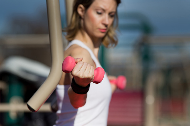 Girl exercising with dumbbells - Fotó, kép