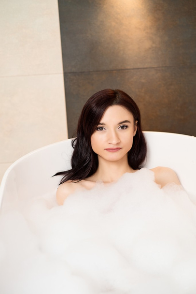 Brunette femme relaxant dans le bain avec de la mousse
 - Photo, image