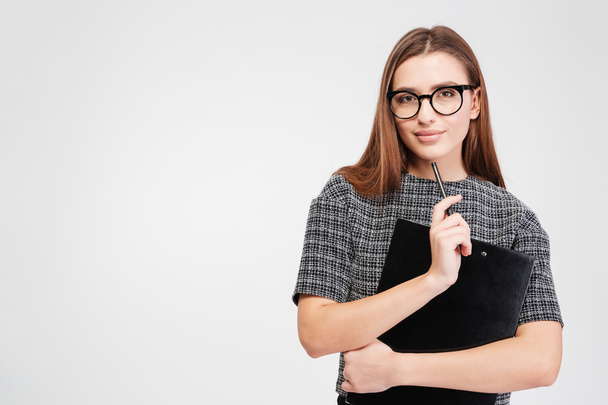 Attractive confident businesswoman in glasses with clipboard and pen  - Photo, image