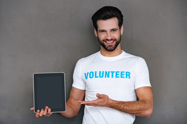 Confident young man in volunteer t-shirt - 写真・画像