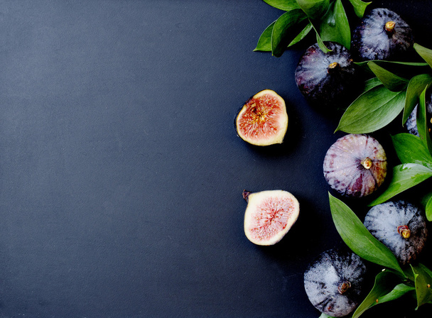 figs with leaves on a black, selective focus - 写真・画像