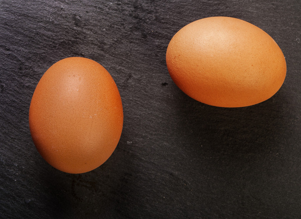 eieren op een zwarte achtergrond - Foto, afbeelding