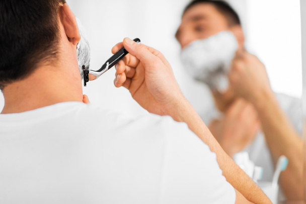 close up of man shaving beard with razor blade - Фото, зображення