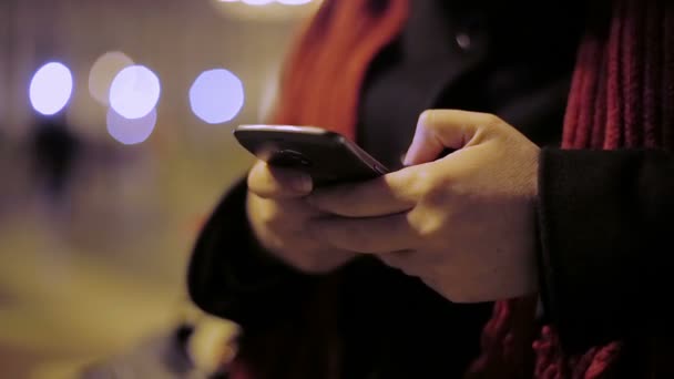 mujer usando smartphone en la ciudad por la noche - Metraje, vídeo