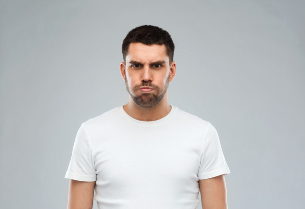 man with funny angry face over gray background - Foto, Imagen
