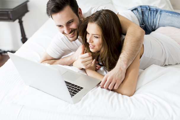 Casal jovem com laptop
 - Foto, Imagem